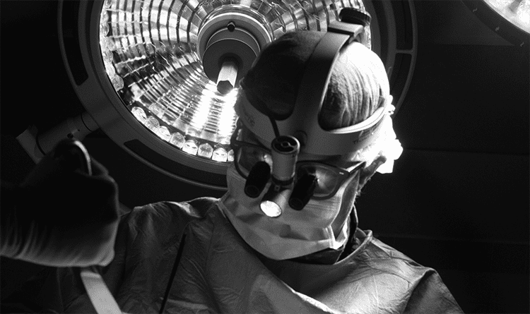 Black and white photo of spine specialist, Colin Crosby, MD, performing surgery
