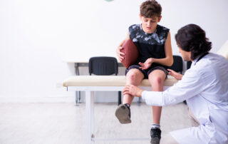 Young football player visits the orthopedic doctor's office after facing an injury.
